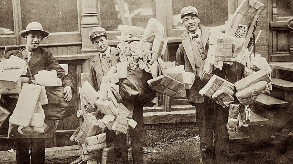 Letter carriers burdened with holiday mail, circa 1915