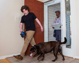 Images of letter carrier delivering to a house with dogs for the dog bite awareness campaign.